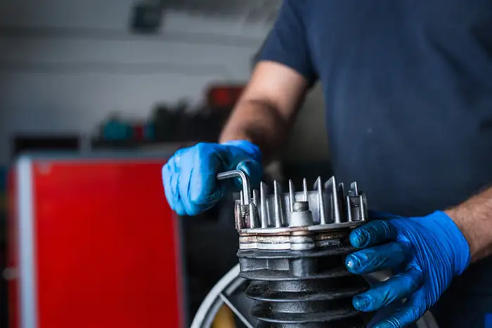Técnico trabajando en el montaje de un motor, asegurando cada componente con precisión.