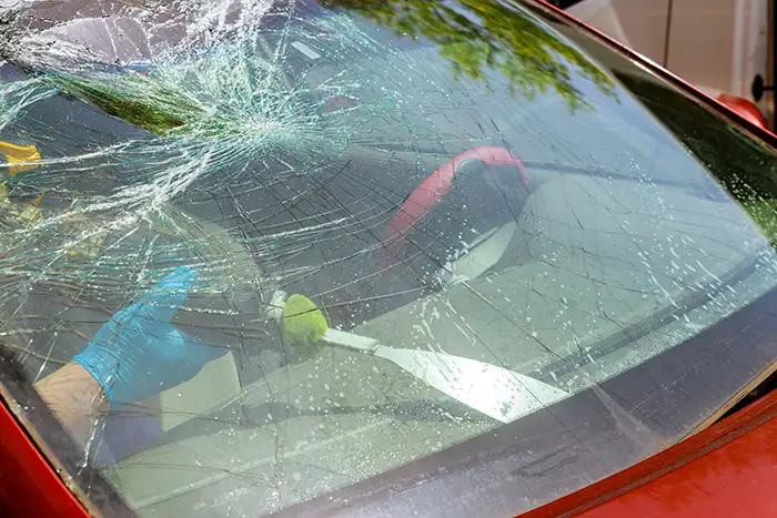 Sustitución de un parabrisas gravemente dañado con grietas extensas en el cristal.
